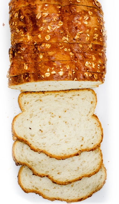 A loaf of sliced bread with oats and flax seeds
